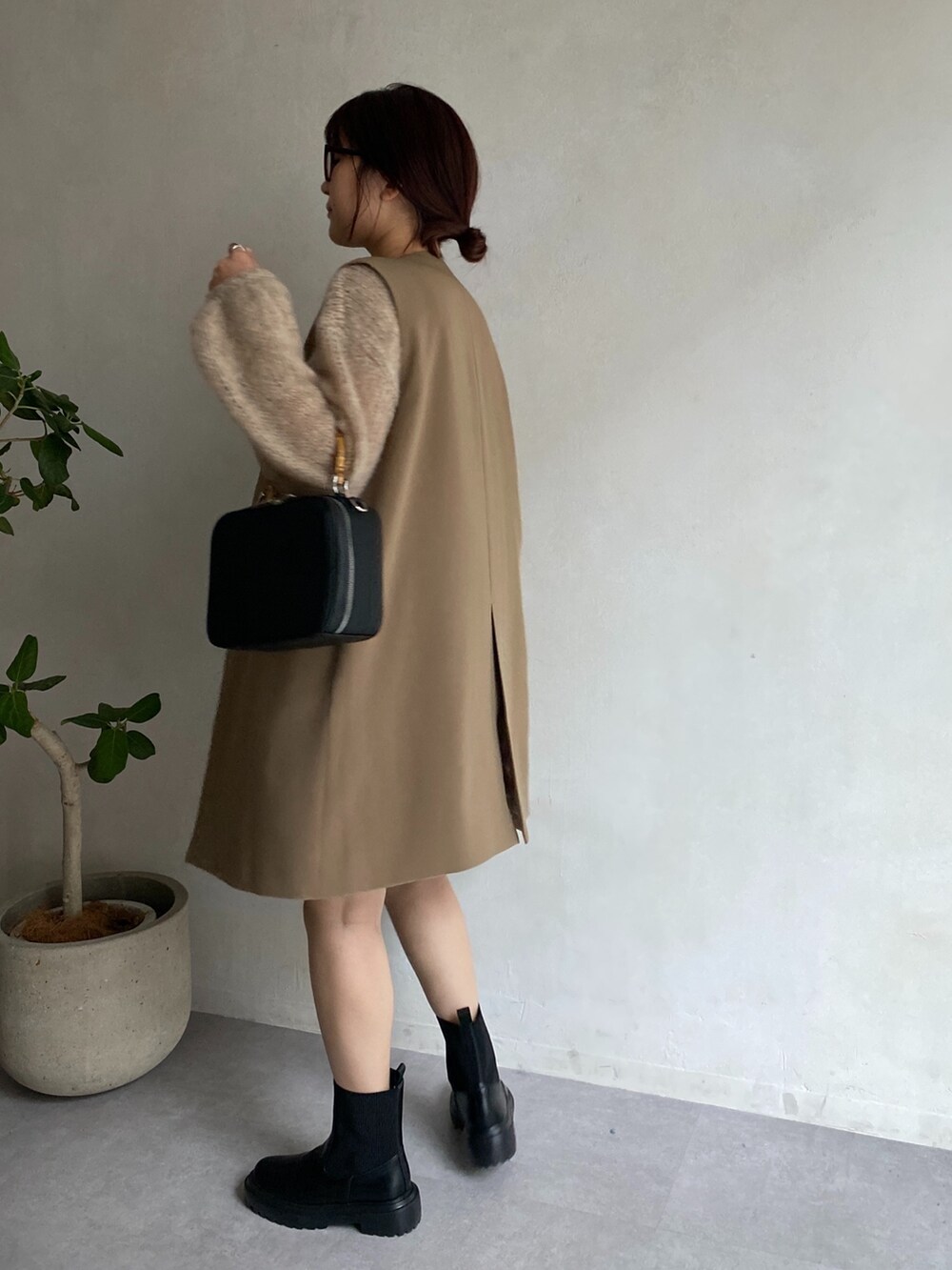 ベージュ系のニット/セーター、イエロー系のベスト、ベージュ系のスカートを着用したレディースの夏コーディネートの3枚目の写真