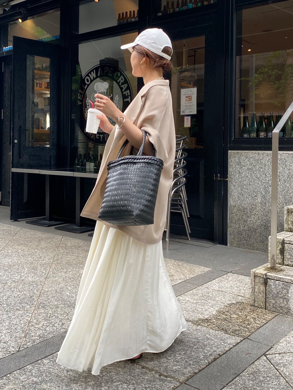 ホワイト系のワンピース、ベージュ系のテーラードジャケット、ホワイト系のキャップを着用したレディースの夏コーディネートの2枚目の写真