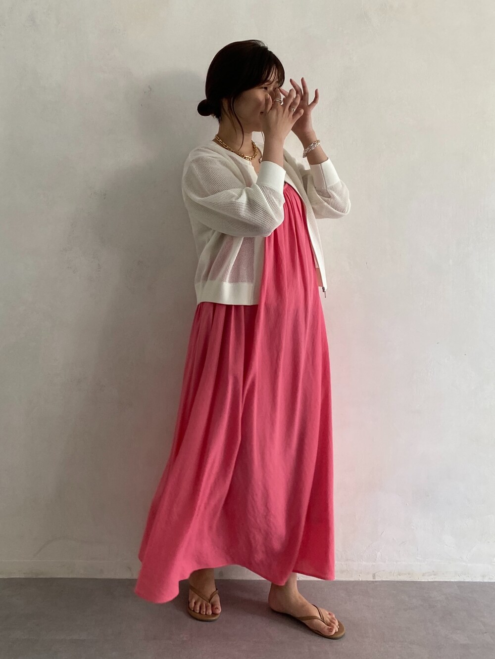 ベージュ系のカーディガン/ボレロ、ピンク系のワンピース、ゴールド系のネックレスを着用したレディースの夏コーディネートの3枚目の写真