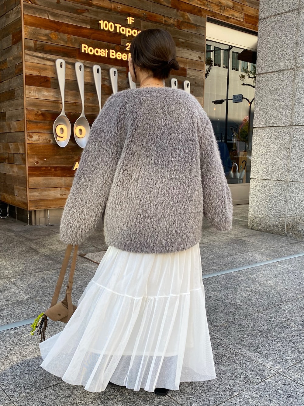 ベージュ系のニット/セーター、ホワイト系のスカート、グレー系のその他アウターを着用したレディースの冬コーディネートの4枚目の写真
