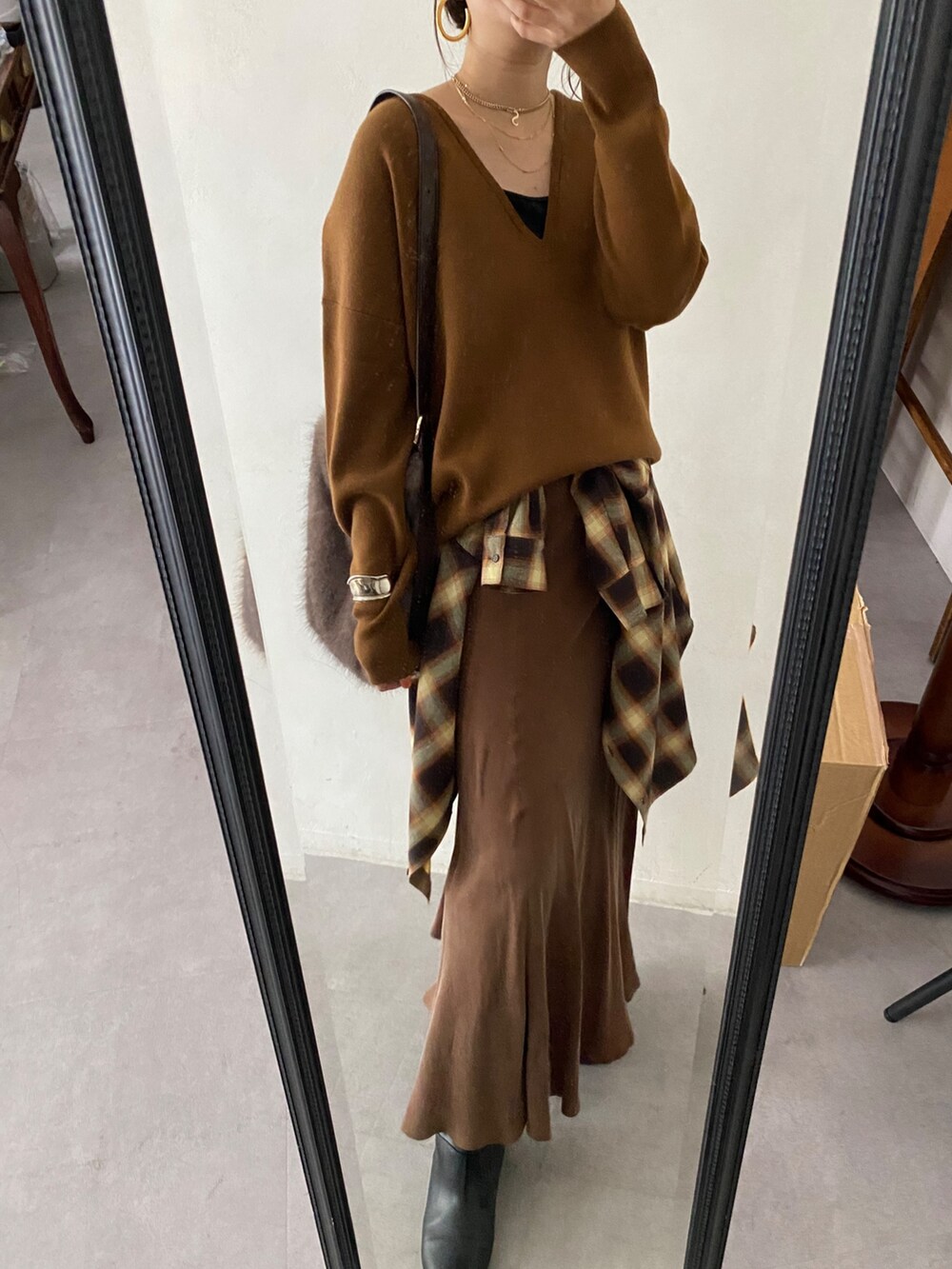 イエロー系のニット/セーター、ブラウン系のスカート、オレンジ系のシャツ/ブラウスを着用したレディースの冬コーディネートの8枚目の写真