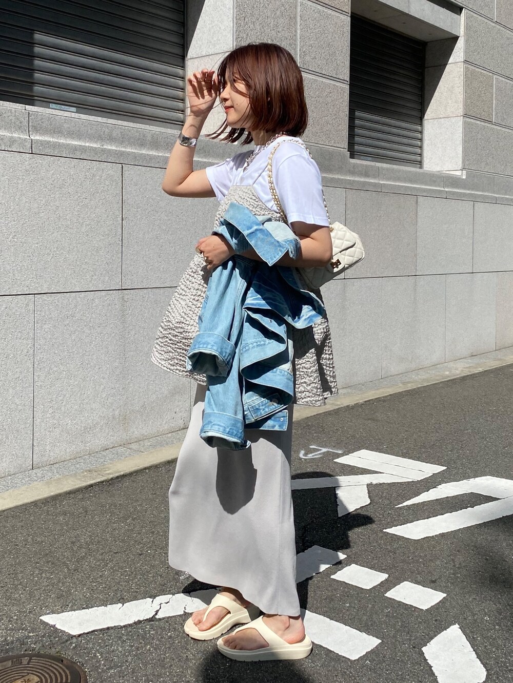 グレー系のキャミソール、ベージュ系のスカート、ブルー系のジャケット/アウターを着用したレディースの春コーディネートの7枚目の写真