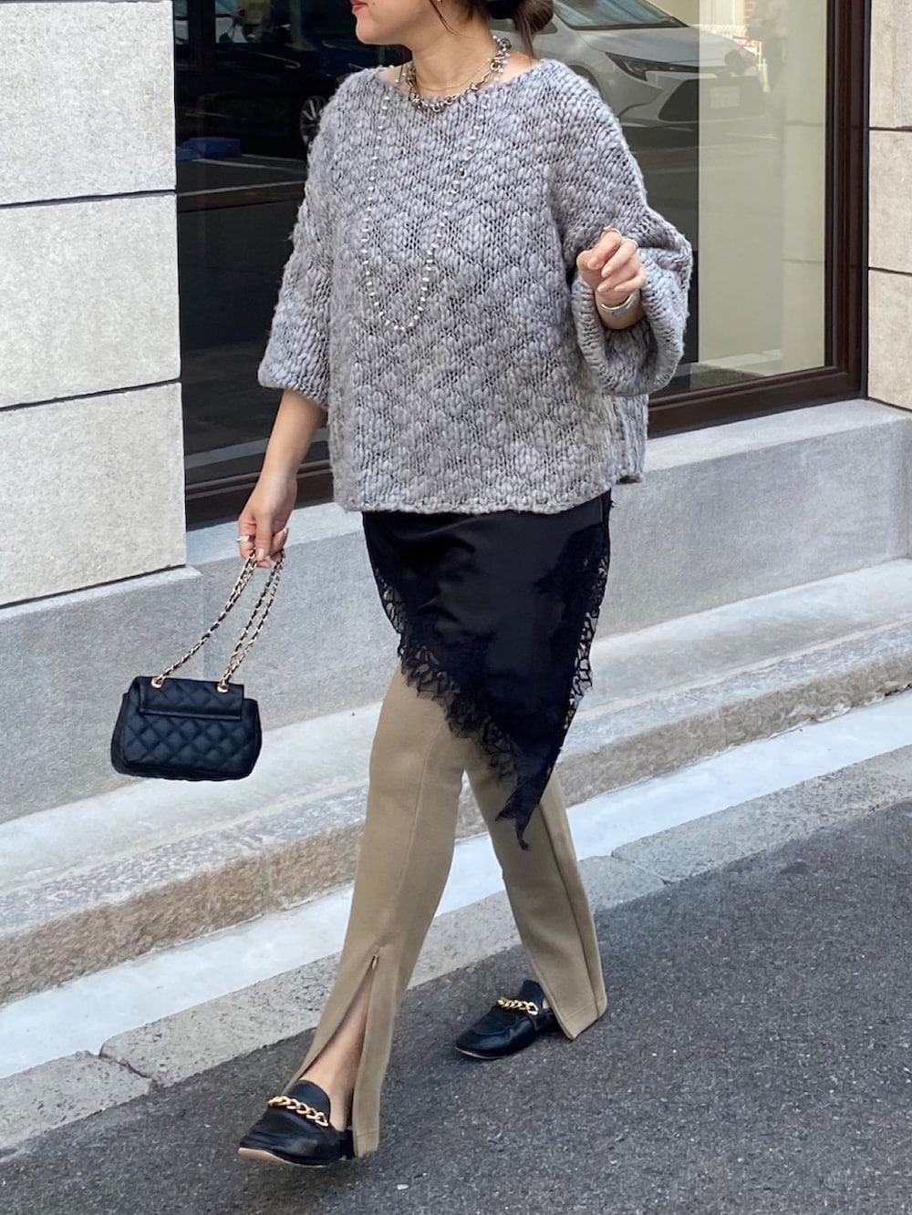 グレー系のニット/セーター、ベージュ系のその他パンツ、ブラック系のショルダーバッグを着用したレディースの冬コーディネートの7枚目の写真