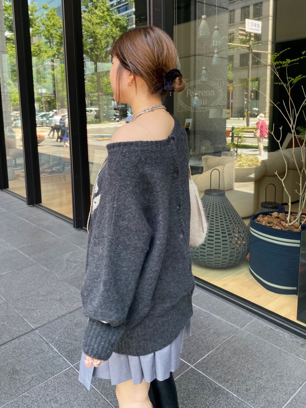 グレー系のニット/セーター、グレー系のスカート、ブラック系のブーツを着用したレディースの秋コーディネートの5枚目の写真