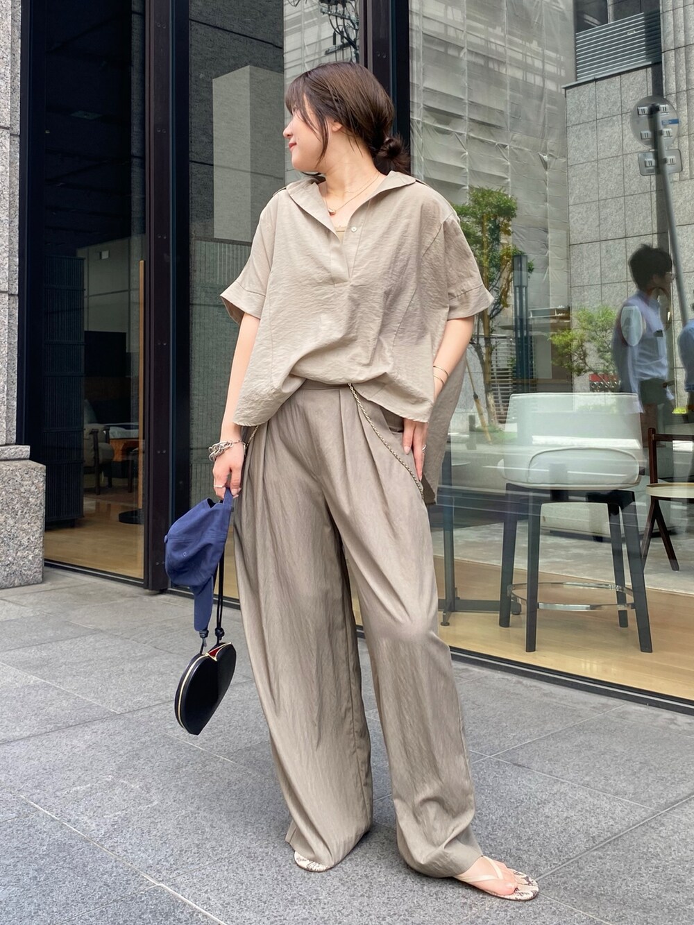 ベージュ系のシャツ/ブラウス、ブラック系のショルダーバッグ、ベージュ系のTシャツ/カットソーを着用したレディースの夏コーディネートの5枚目の写真