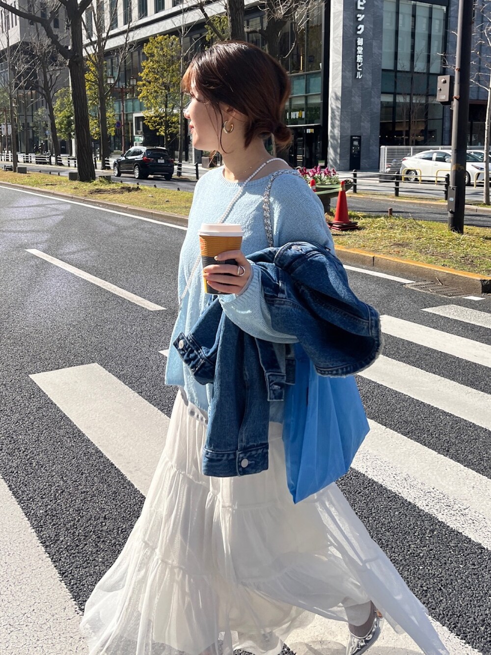 ブルー系のデニムジャケット、グレー系のニット/セーター、ホワイト系のTシャツ/カットソーを着用したレディースの春コーディネートの9枚目の写真