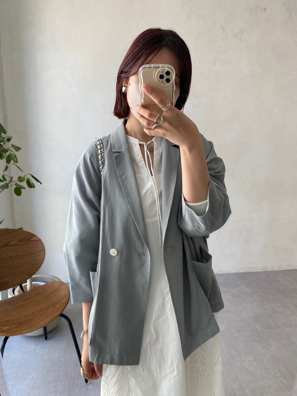 グレー系のテーラードジャケット、ホワイト系のワンピース/ドレス、シルバー系のショルダーバッグを着用したレディースの春コーディネートの7枚目の写真