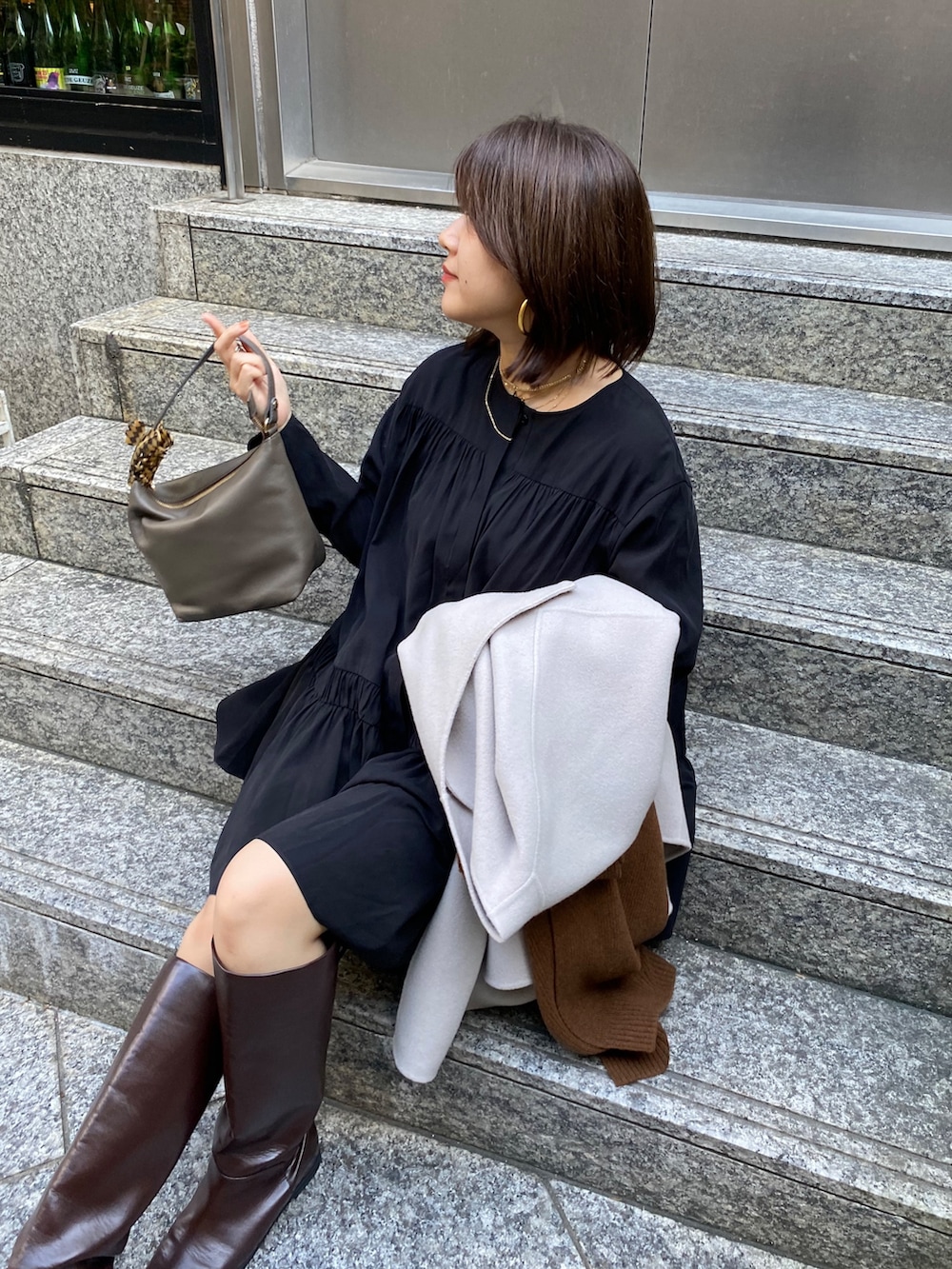 ブラック系のシャツ/ブラウス、ブラウン系のブーツ、ブラウン系のショルダーバッグを着用したレディースの秋コーディネートの7枚目の写真