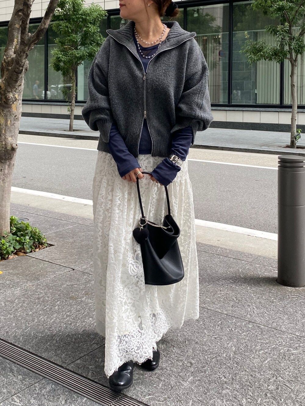 グレー系のカーディガン/ボレロ、ブルー系のTシャツ/カットソー、ホワイト系のスカートを着用したレディースの秋コーディネートの5枚目の写真