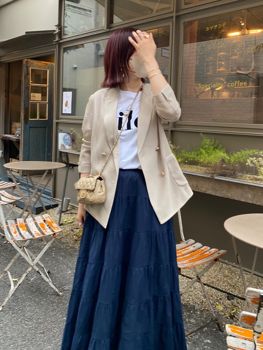 ベージュ系のテーラードジャケット、ホワイト系のTシャツ/カットソー、ブルー系のスカートを着用したレディースの春コーディネートの4枚目の写真