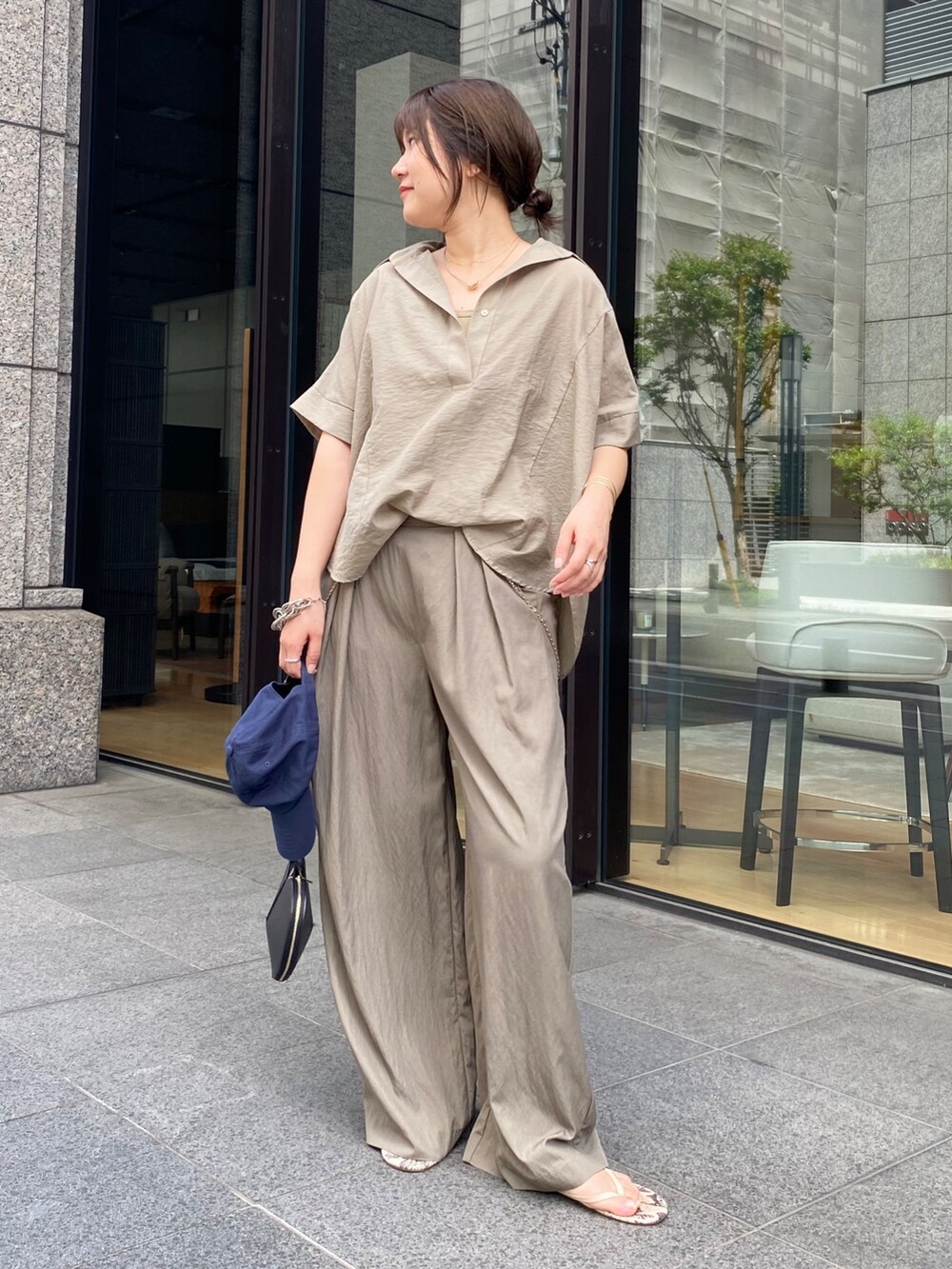 ベージュ系のシャツ/ブラウス、ブラック系のショルダーバッグ、ベージュ系のTシャツ/カットソーを着用したレディースの夏コーディネートの2枚目の写真