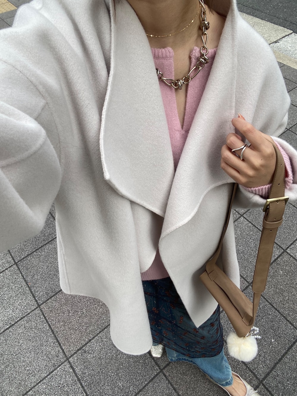 ホワイト系のその他アウター、ピンク系のニット/セーター、ブラック系のスカートを着用したレディースの冬コーディネートの4枚目の写真