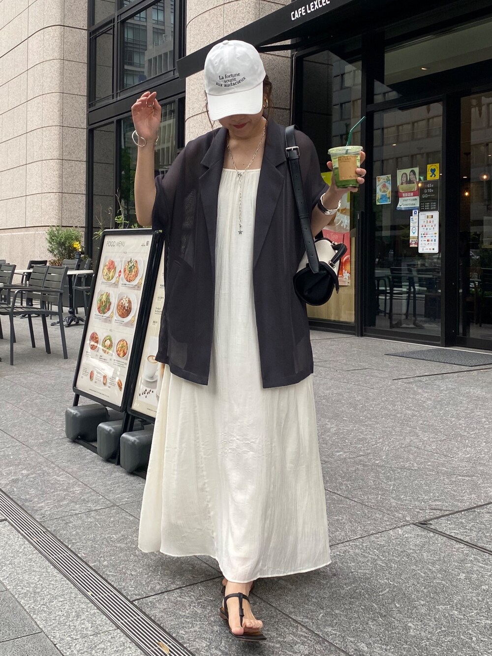 グレー系のテーラードジャケット、ホワイト系のワンピース、ホワイト系のキャップを着用したレディースの夏コーディネートの5枚目の写真