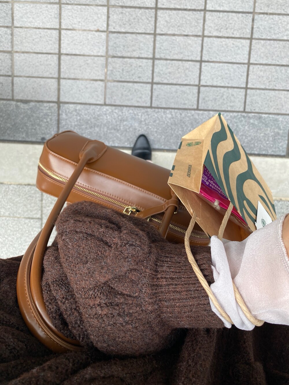 ブラウン系のニット/セーター、ピンク系のスカート、ブラック系のブーツを着用したレディースの冬コーディネートの5枚目の写真