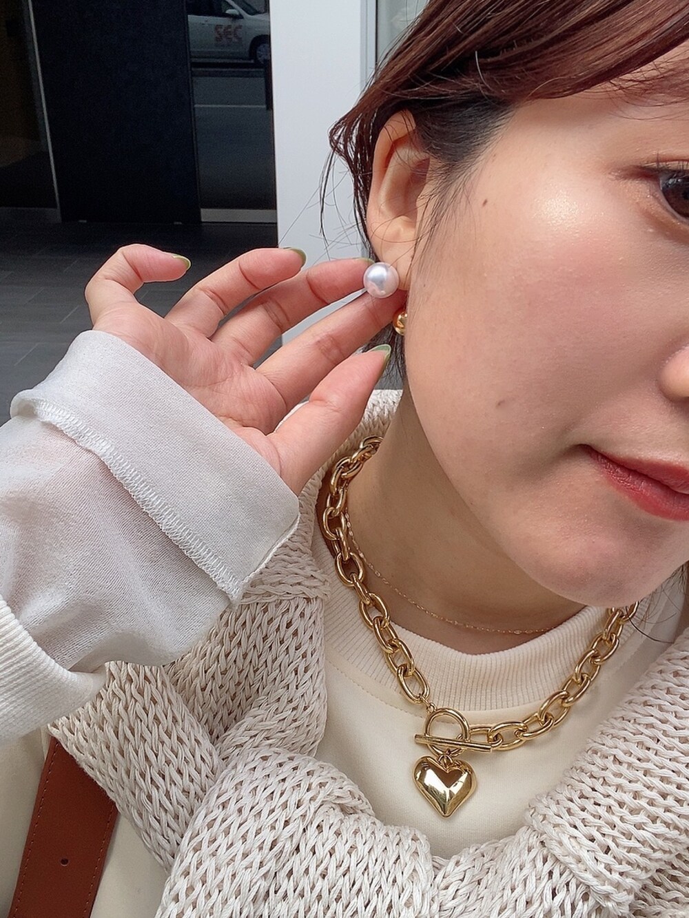 ホワイト系のワンピース、ブラック系のブーツ、シルバー系のネックレスを着用したレディースの冬コーディネートの6枚目の写真