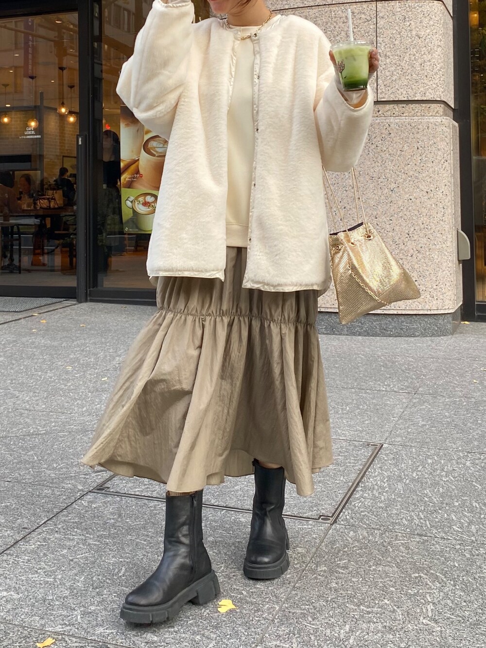 ホワイト系のダウンジャケット/コート、ゴールド系のショルダーバッグ、ホワイト系のワンピースを着用したレディースの冬コーディネートの5枚目の写真