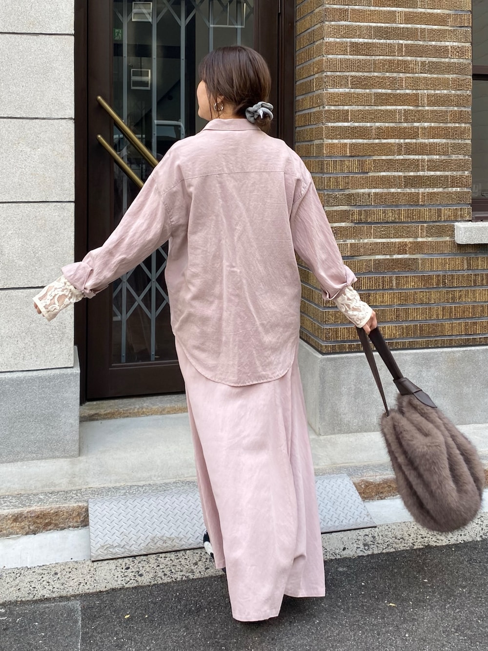 ピンク系のシャツ/ブラウス、ピンク系のスカート、ブラウン系のショルダーバッグを着用したレディースの冬コーディネートの3枚目の写真