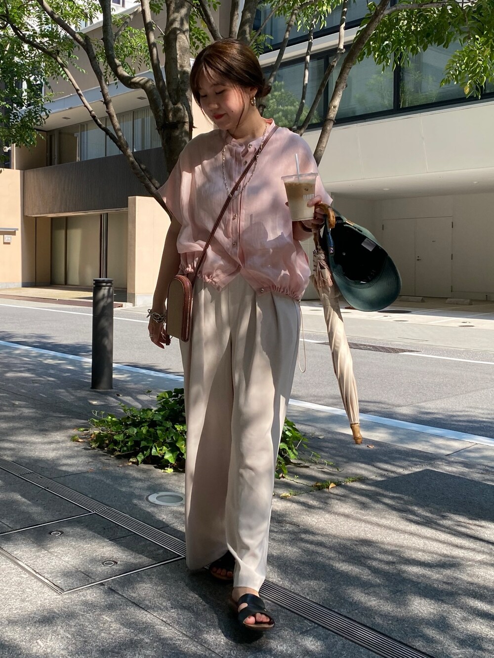 ピンク系のシャツ/ブラウス、ホワイト系のスラックス、ゴールド系のネックレスを着用したレディースの夏コーディネートの5枚目の写真