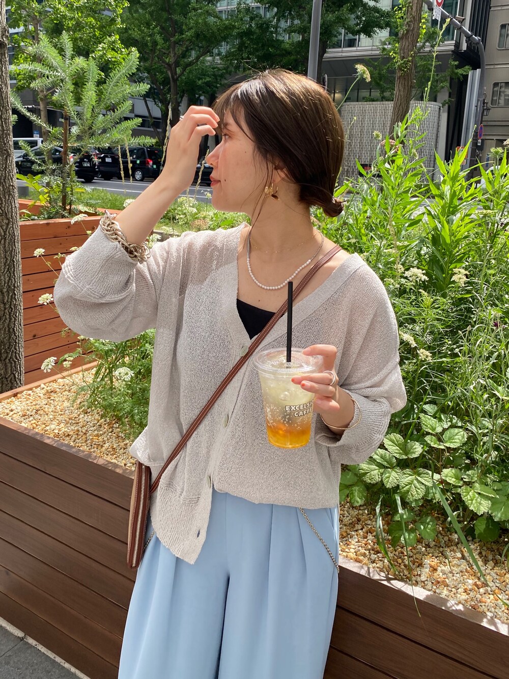 グレー系のカーディガン/ボレロ、ブルー系のスラックス、ゴールド系のサスペンダーを着用したレディースの夏コーディネートの2枚目の写真