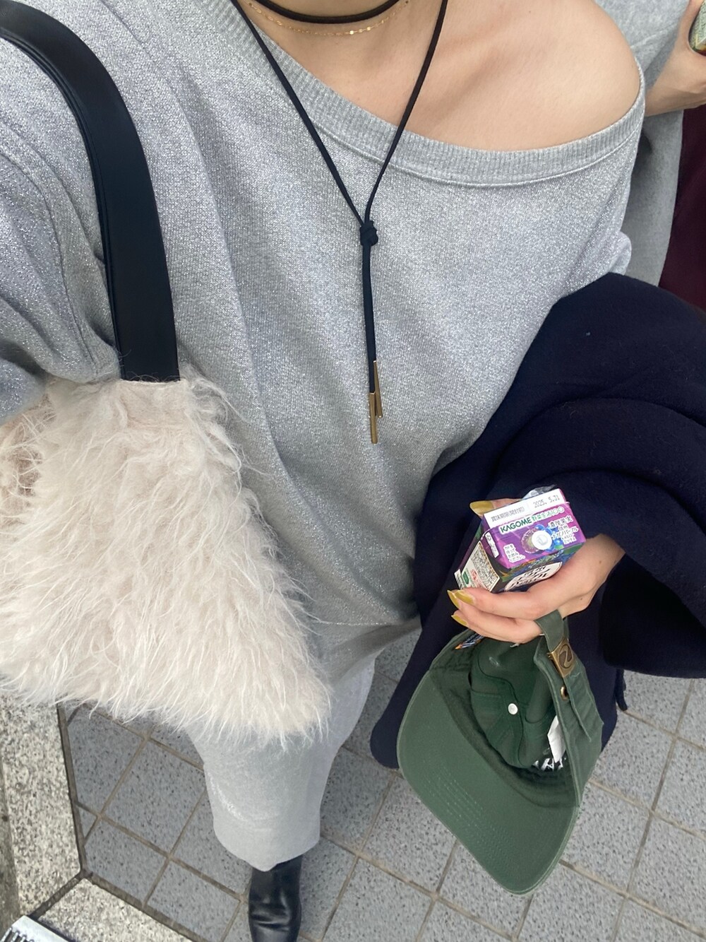 シルバー系のスウェット、シルバー系のスカート、ブラック系のブーツを着用したレディースの秋コーディネートの7枚目の写真