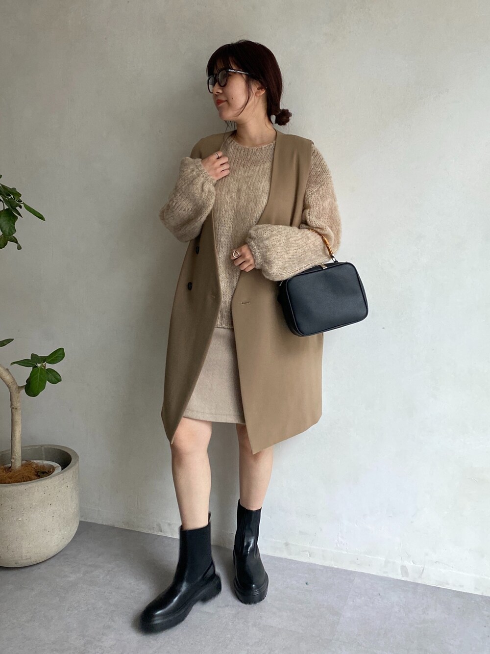 ベージュ系のニット/セーター、イエロー系のベスト、ベージュ系のスカートを着用したレディースの夏コーディネートの2枚目の写真