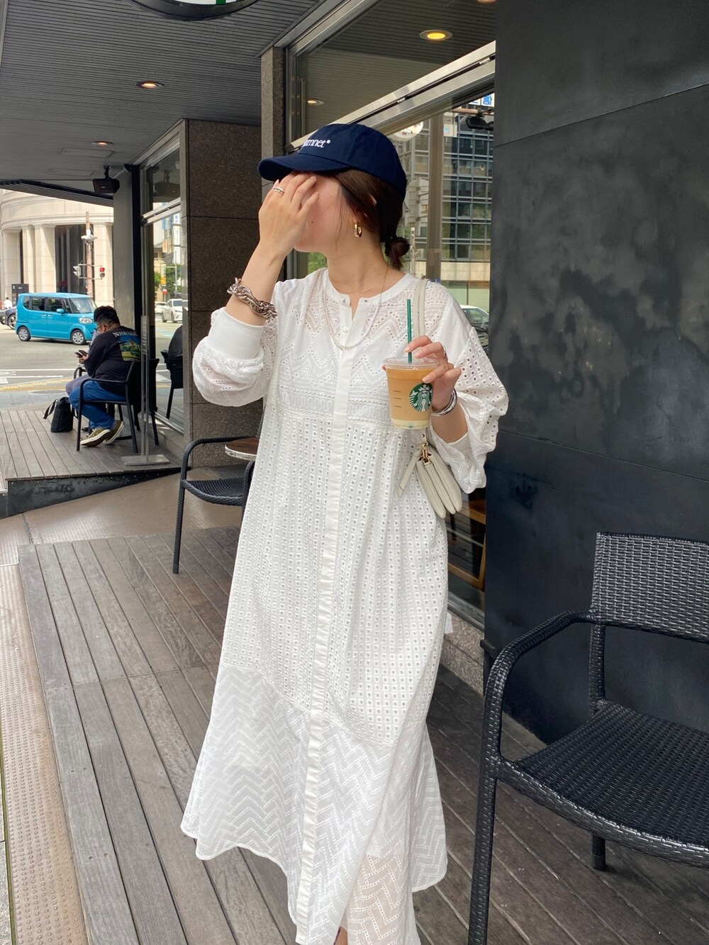 ホワイト系のワンピース、ホワイト系のショルダーバッグ、ゴールド系のブレスレットを着用したレディースの夏コーディネートの3枚目の写真