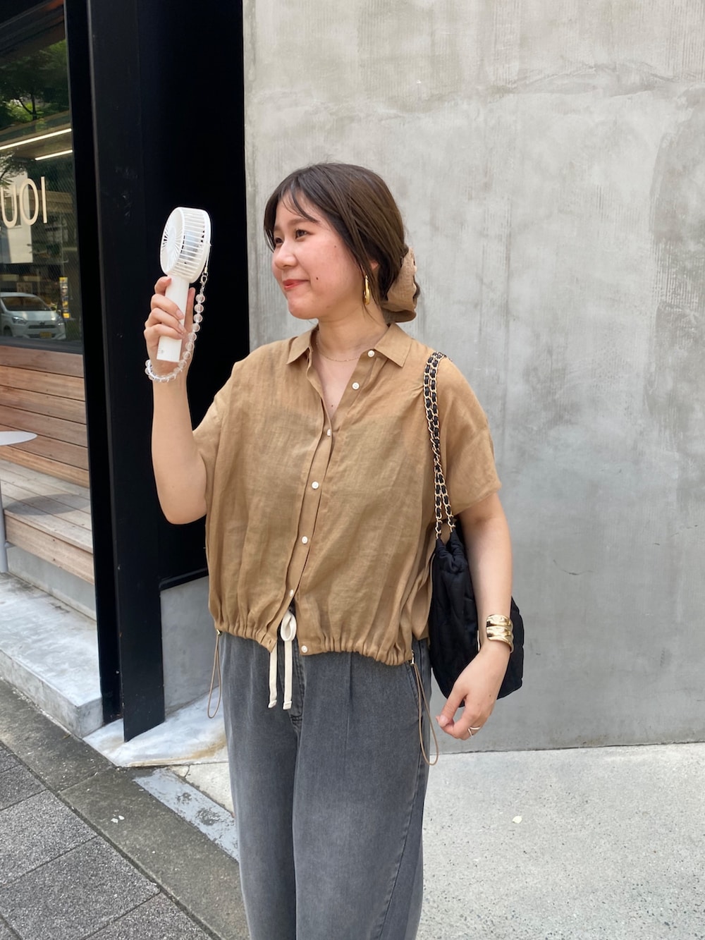 ベージュ系のシャツ/ブラウス、ブラック系のデニムパンツ、ブラック系のショルダーバッグを着用したレディースの夏コーディネートの2枚目の写真
