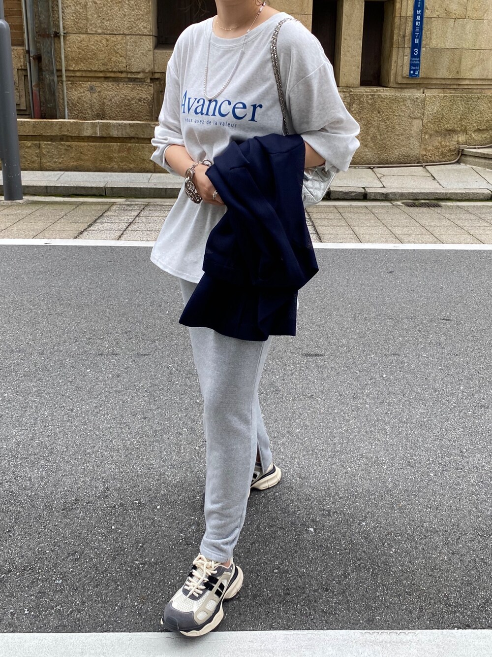 ベージュ系のテーラードジャケット、グレー系のTシャツ/カットソー、シルバー系のスカートを着用したレディースの夏コーディネートの6枚目の写真