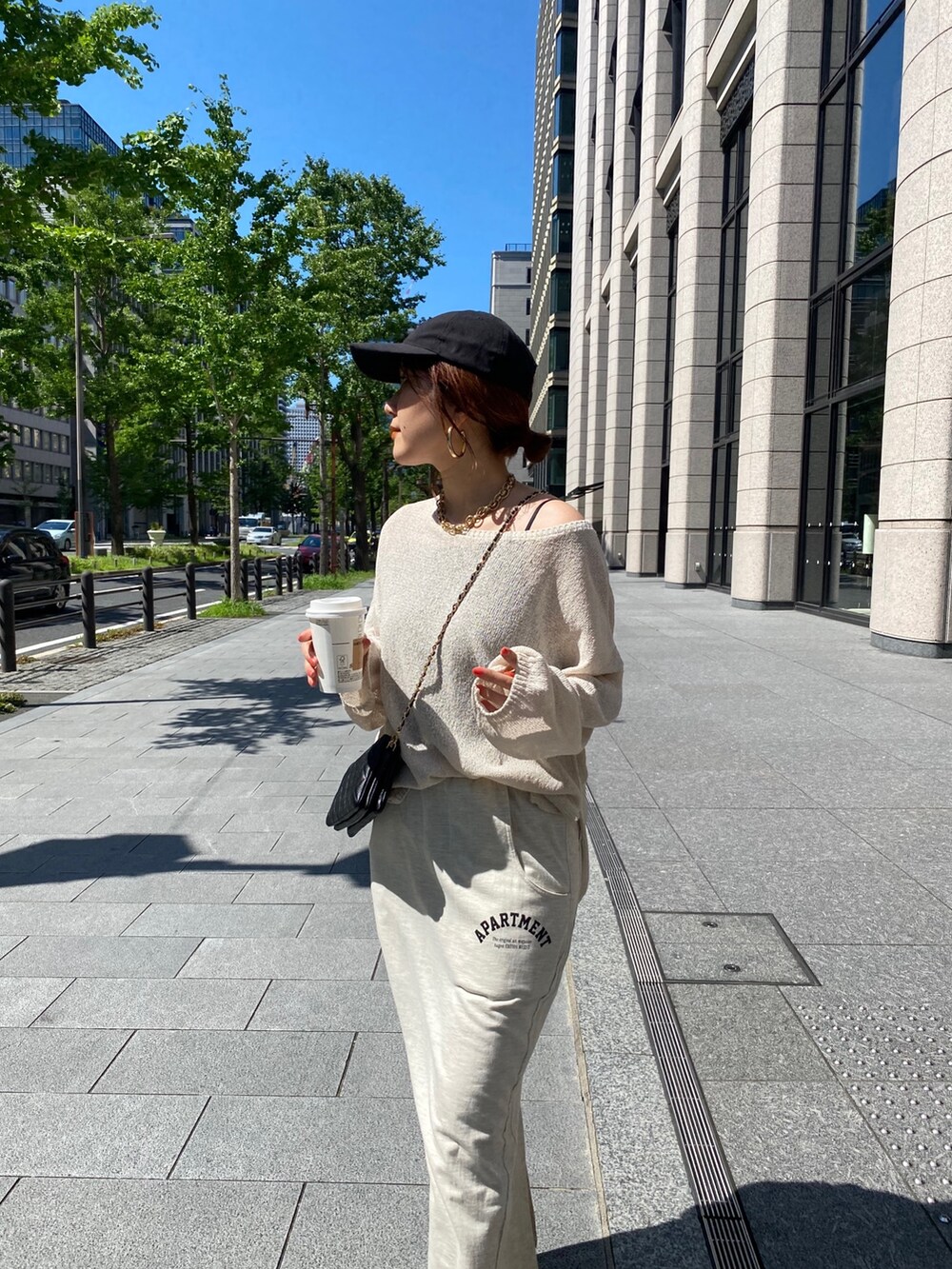 ベージュ系のニット/セーター、ベージュ系のスカート、ブラック系のショルダーバッグを着用したレディースの夏コーディネートの9枚目の写真