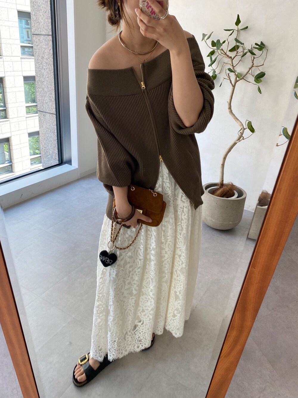 ブラウン系のニット/セーター、イエロー系のショルダーバッグ、ホワイト系のスカートを着用したレディースの秋コーディネートの5枚目の写真