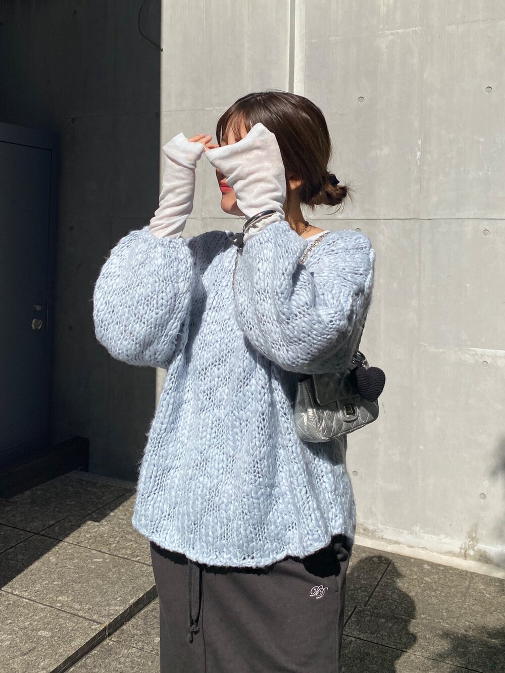 ブルー系のニット/セーター、ブルー系のTシャツ/カットソー、グレー系のムートンコートを着用したレディースの冬コーディネートの9枚目の写真