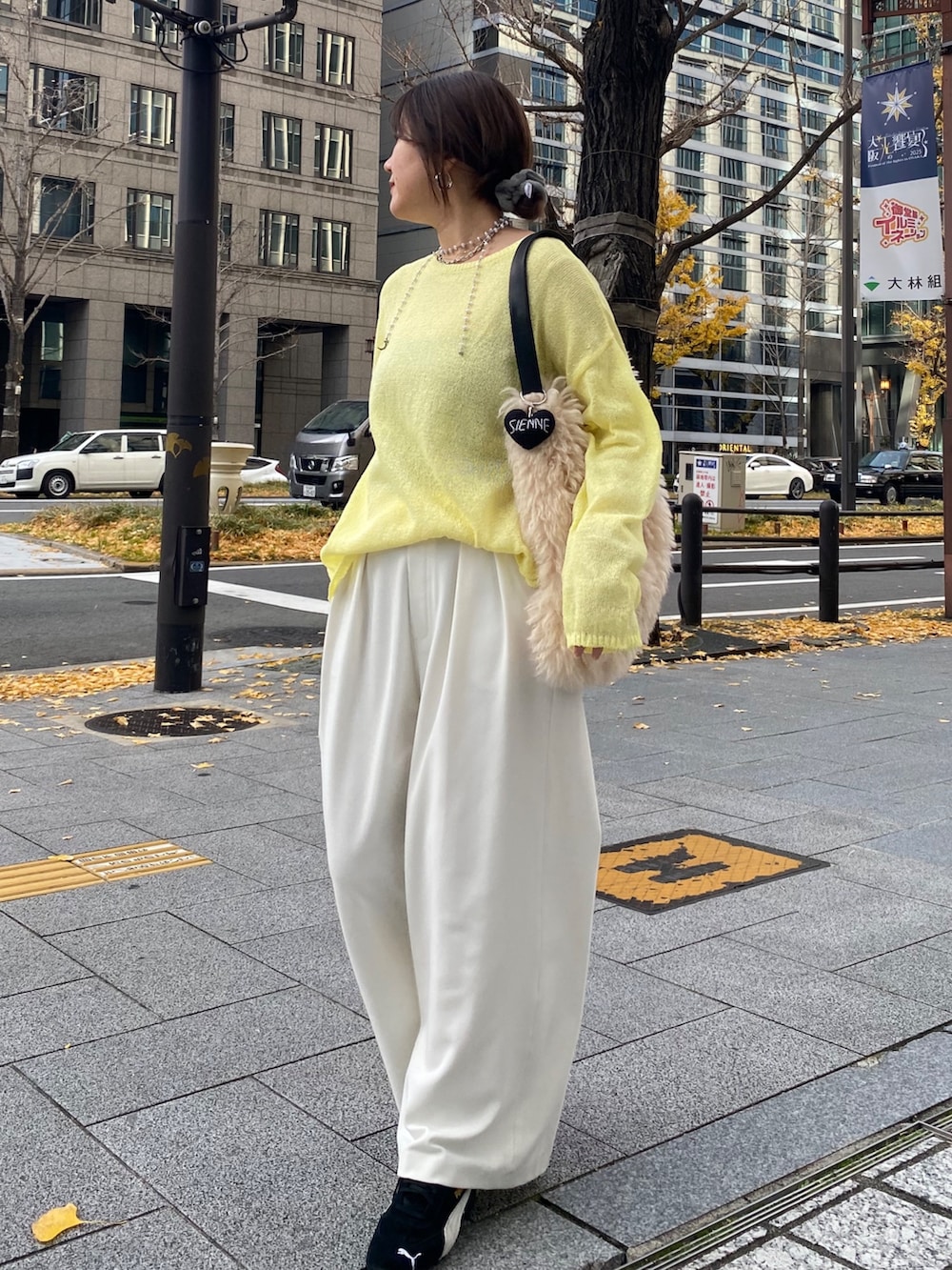 イエロー系のニット/セーター、イエロー系のTシャツ/カットソー、ホワイト系のその他パンツを着用したレディースの冬コーディネートの2枚目の写真