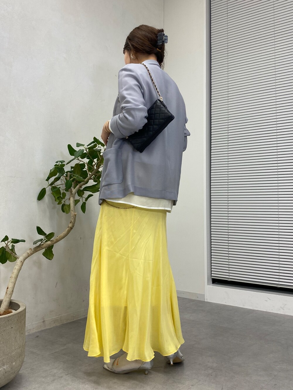 イエロー系のスカート、ホワイト系のシャツ/ブラウス、ブラック系のショルダーバッグを着用したレディースの冬コーディネートの4枚目の写真