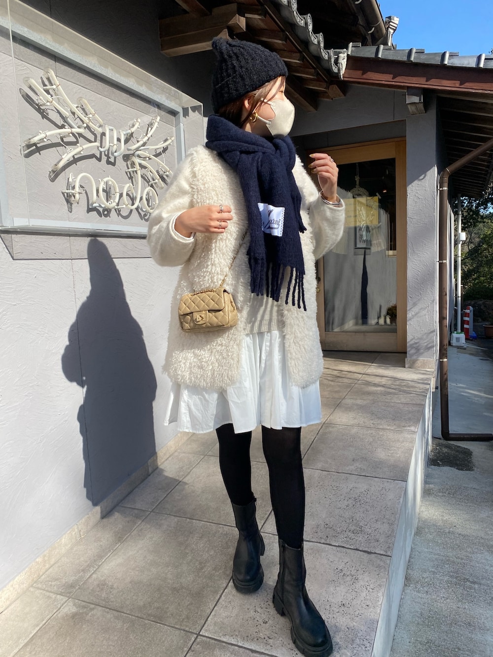 ホワイト系のベスト、ホワイト系のニット/セーター、ホワイト系のシャツ/ブラウスを着用したレディースの冬コーディネートの2枚目の写真