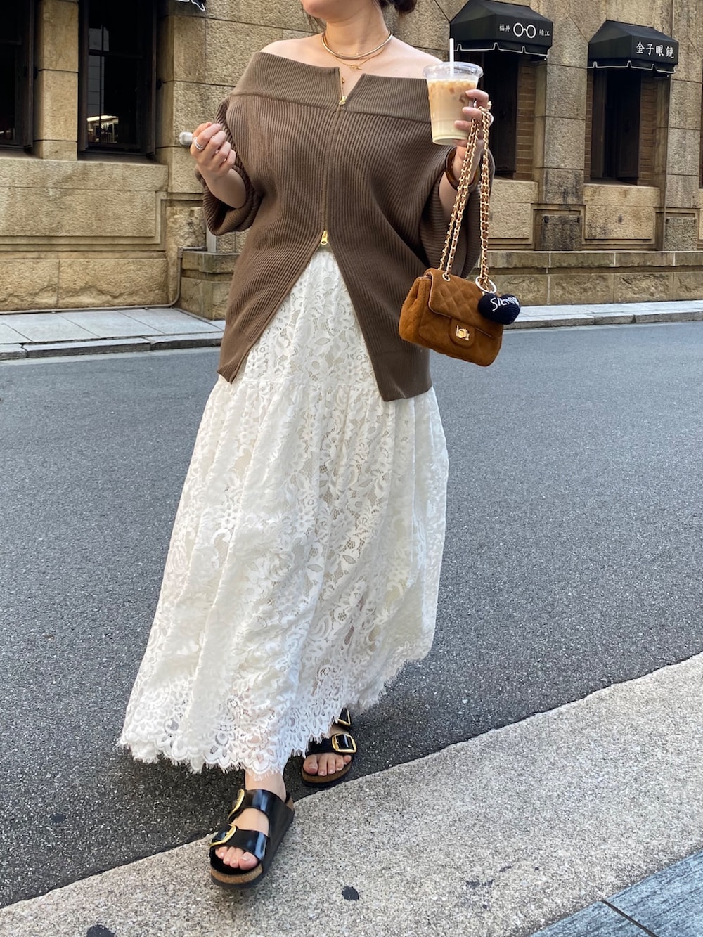 ブラウン系のニット/セーター、イエロー系のショルダーバッグ、ホワイト系のスカートを着用したレディースの秋コーディネートの3枚目の写真