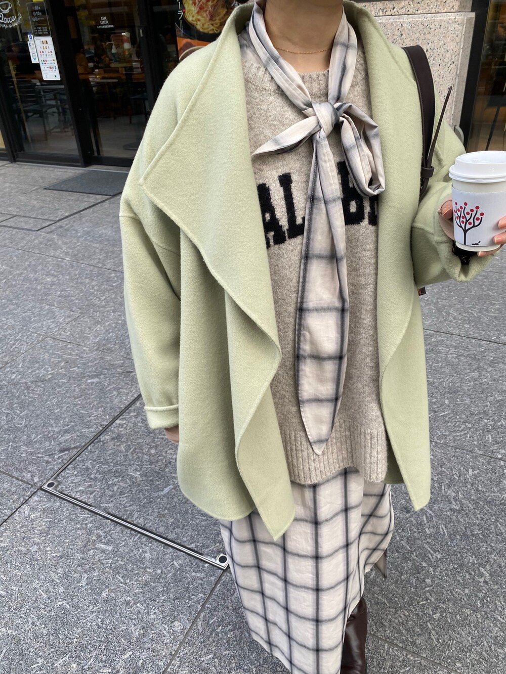 ホワイト系のワンピース、ホワイト系のニット/セーター、ブラウン系のブーツを着用したレディースの冬コーディネートの9枚目の写真