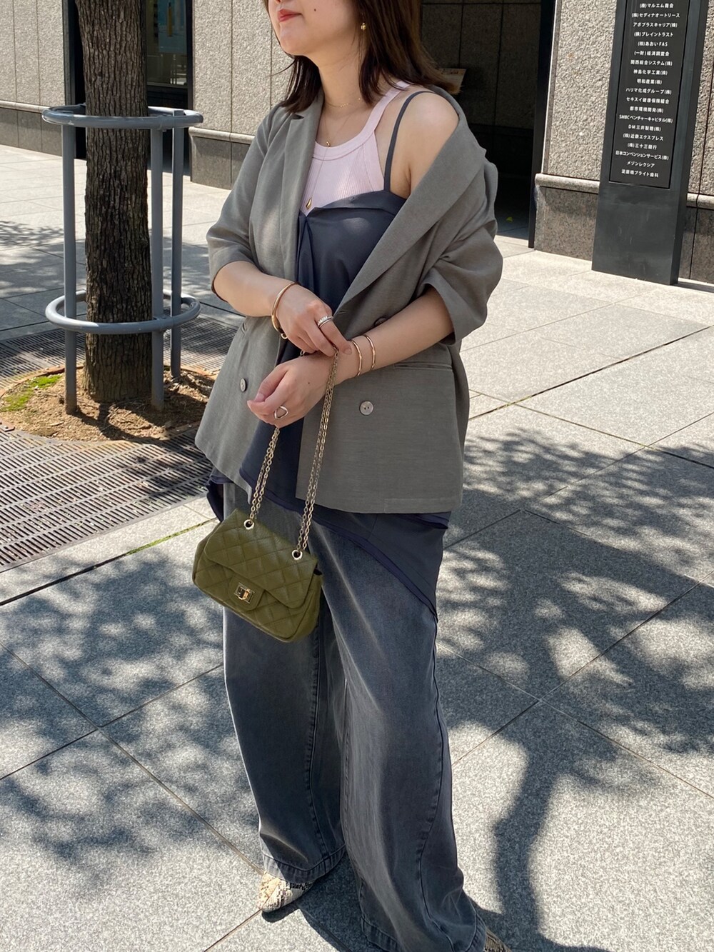 グレー系のテーラードジャケット、ブラック系のデニムパンツ、グレー系のシャツ/ブラウスを着用したレディースの夏コーディネートの3枚目の写真
