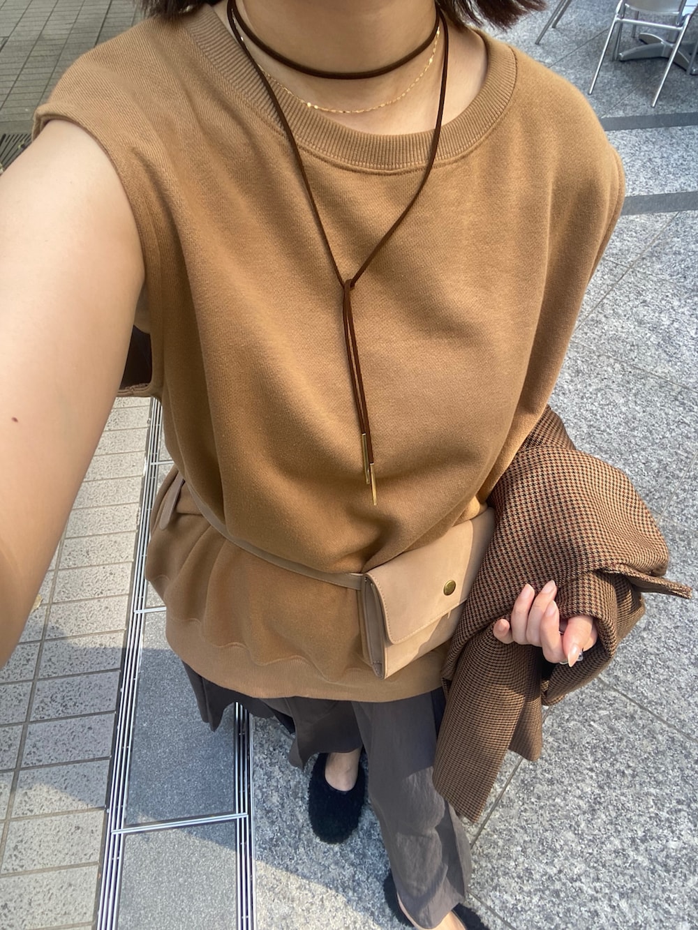 イエロー系のスウェット、グレー系のスカート、ブラウン系のテーラードジャケットを着用したレディースの夏コーディネートの4枚目の写真