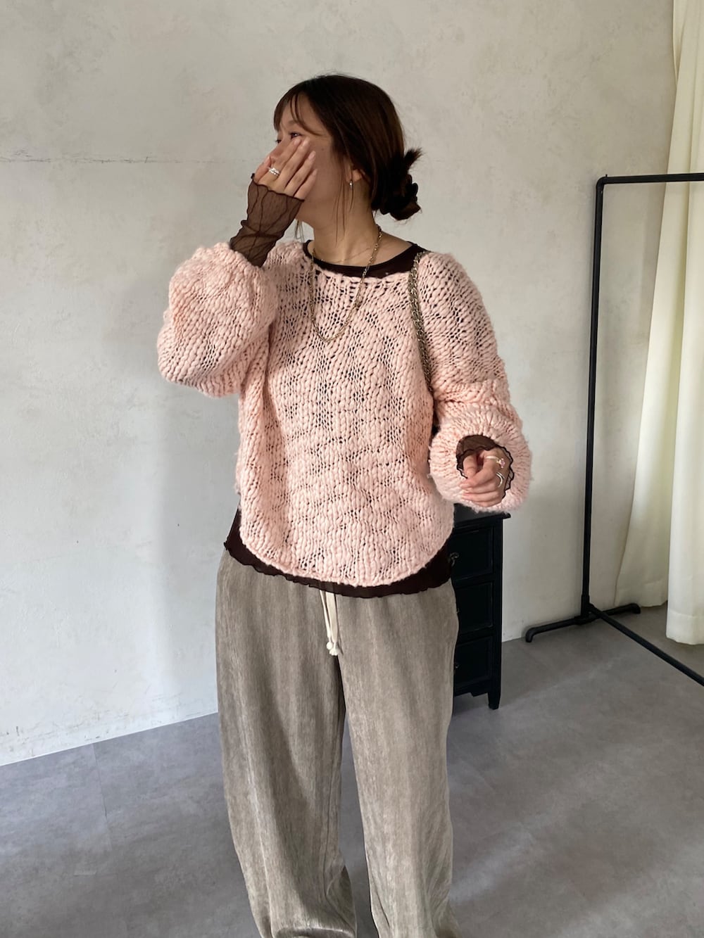 ピンク系のニット/セーター、ブラウン系のTシャツ/カットソー、ベージュ系のその他パンツを着用したレディースの冬コーディネートの2枚目の写真