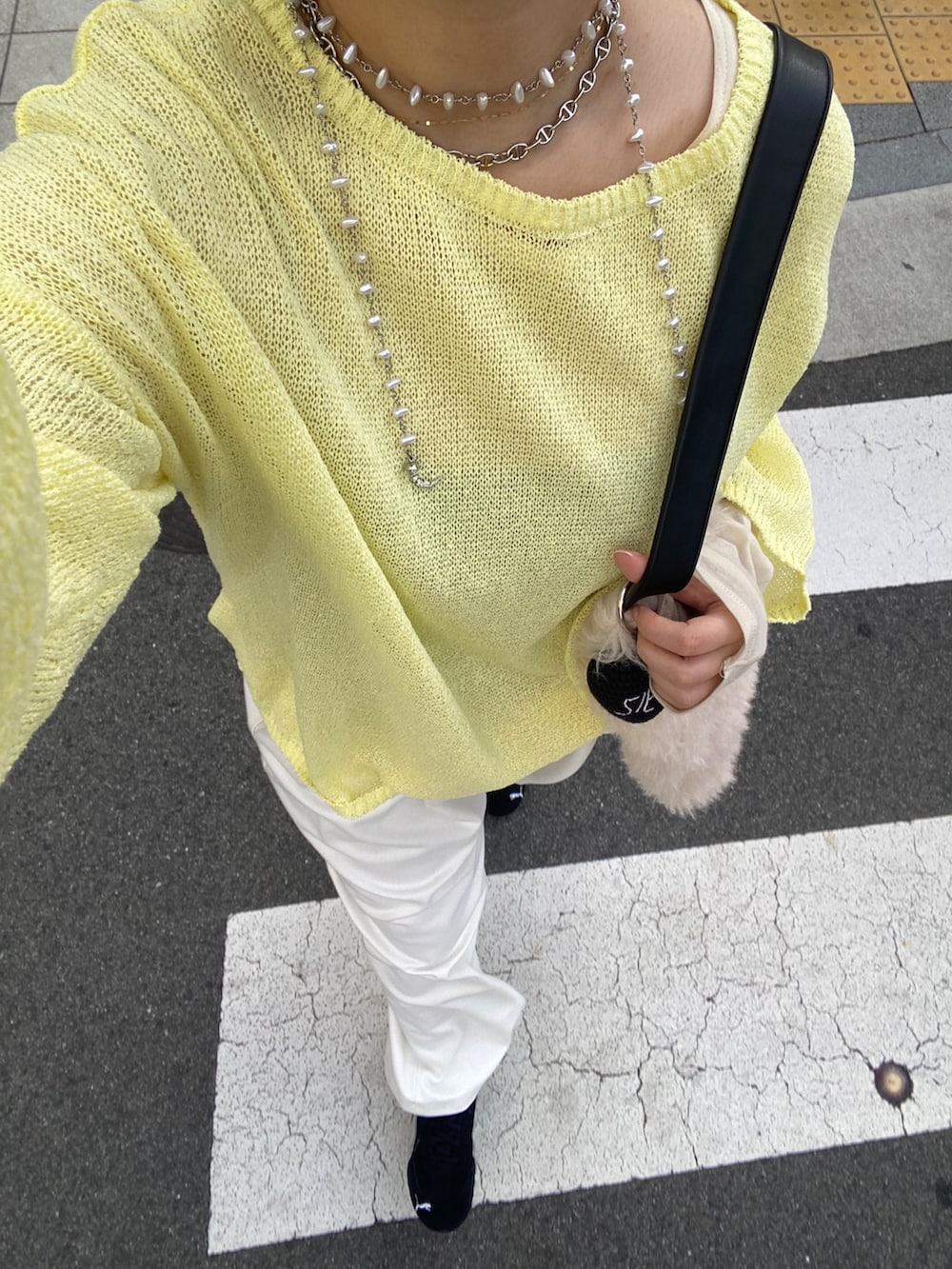 イエロー系のニット/セーター、イエロー系のTシャツ/カットソー、ホワイト系のその他パンツを着用したレディースの冬コーディネートの3枚目の写真