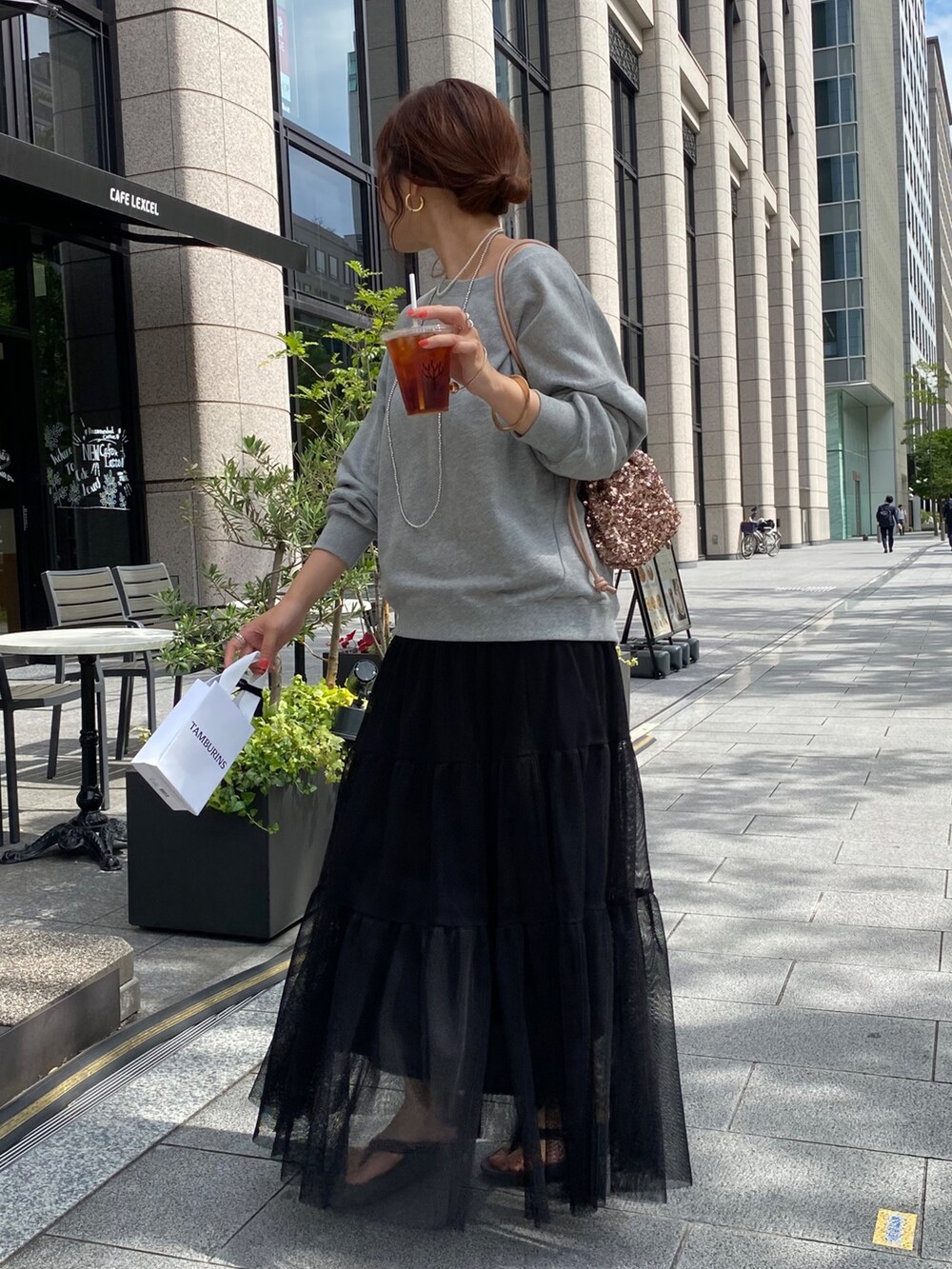 グレー系のスウェット、ブラック系のスカート、ピンク系のハンドバッグを着用したレディースの秋コーディネートの6枚目の写真