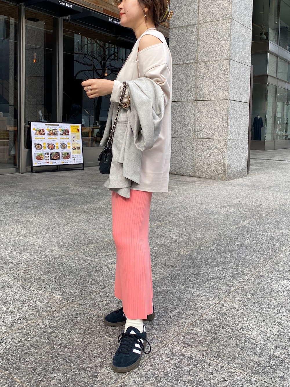 ピンク系のスカート、グレー系のテーラードジャケット、ブルー系のショルダーバッグを着用したレディースの冬コーディネートの3枚目の写真