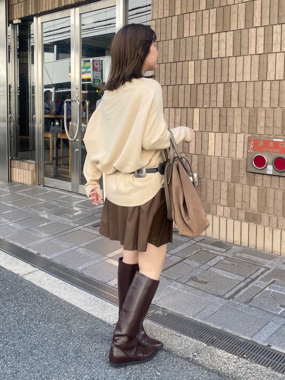 ベージュ系のニット/セーター、ブラウン系のスカート、ブラウン系のショルダーバッグを着用したレディースの冬コーディネートの5枚目の写真