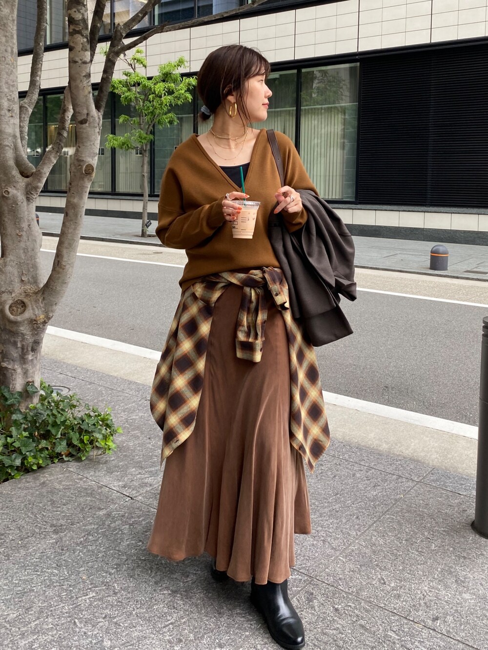 イエロー系のニット/セーター、ブラウン系のスカート、オレンジ系のシャツ/ブラウスを着用したレディースの冬コーディネートの7枚目の写真