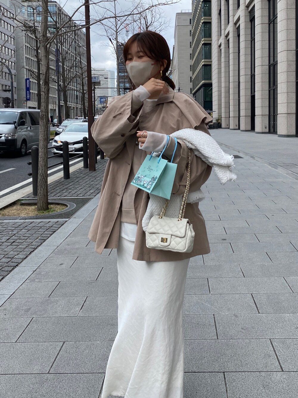 ベージュ系のジャケット/アウター、ホワイト系のスカート、ベージュ系のサンダルを着用したレディースの春コーディネートの3枚目の写真