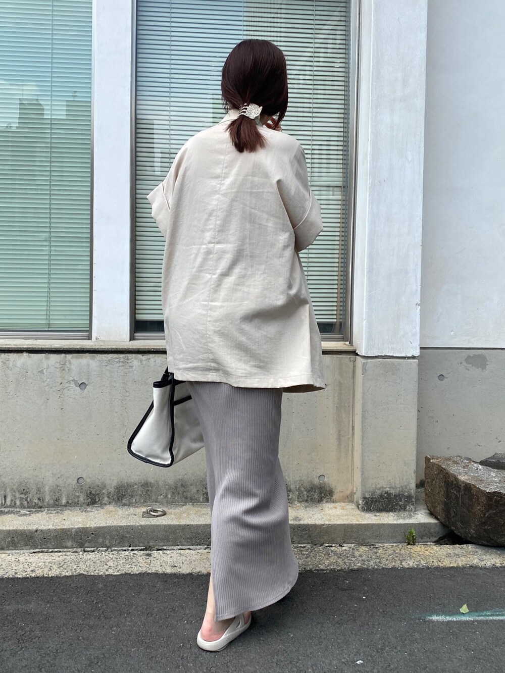 グレー系のワンピース、ベージュ系のテーラードジャケットを着用したレディースの夏コーディネートの4枚目の写真