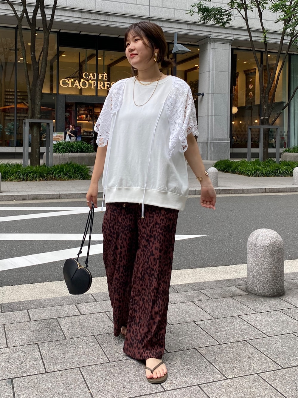 ホワイト系のスウェット、レッド系のその他パンツ、ブラック系のショルダーバッグを着用したレディースの夏コーディネートの4枚目の写真