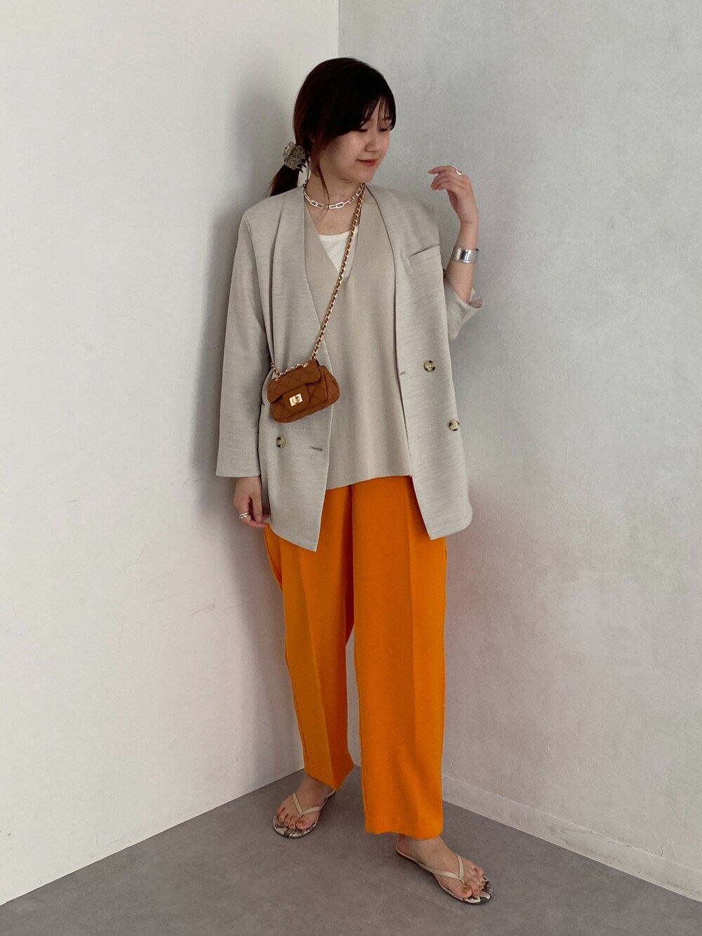 ベージュ系のノーカラージャケット、オレンジ系のその他パンツ、イエロー系のショルダーバッグを着用したレディースの夏コーディネートの3枚目の写真
