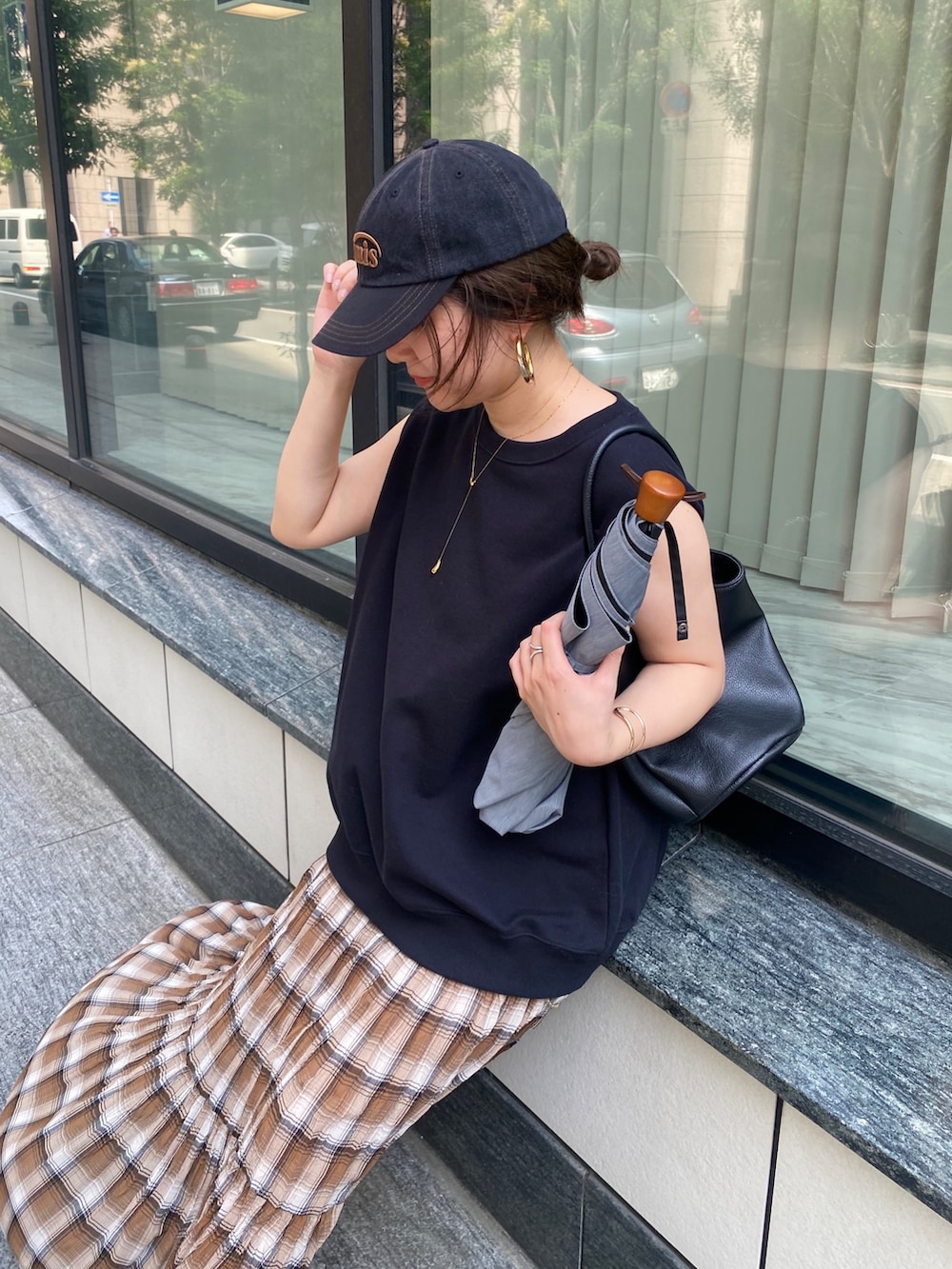 ブラック系のTシャツ/カットソー、ブラウン系のスカート、ブラック系のショルダーバッグを着用したレディースの夏コーディネートの2枚目の写真