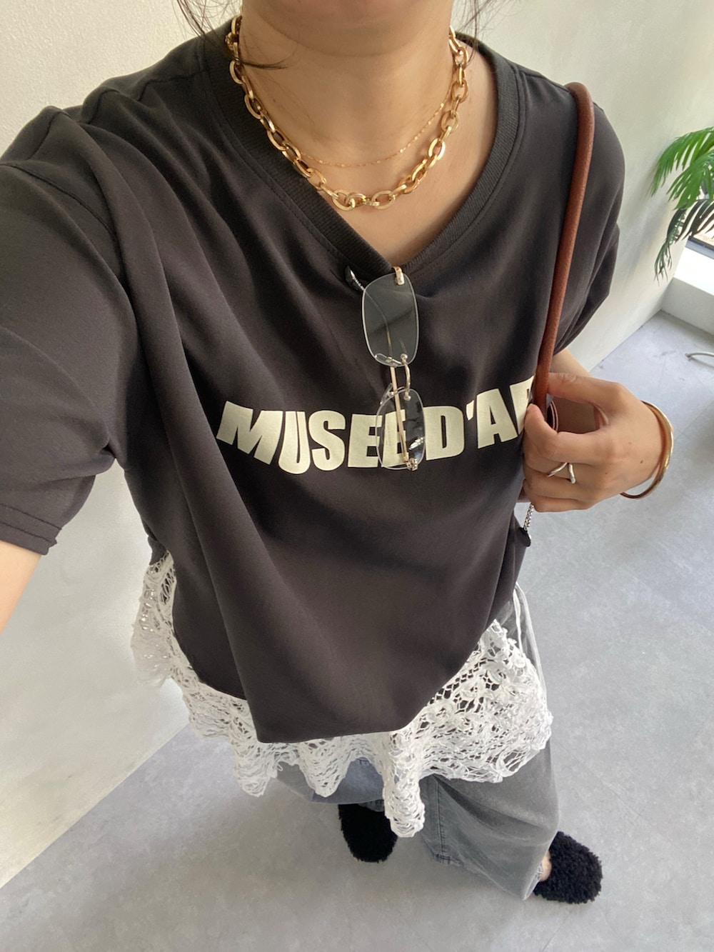 グレー系のシャツ/ブラウス、ブラック系のデニムパンツ、ブラック系のバレエシューズを着用したレディースの夏コーディネートの4枚目の写真